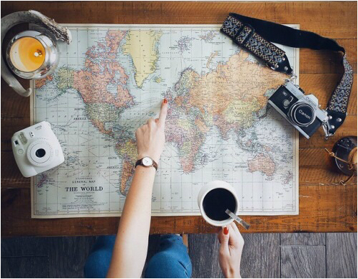 Travel planning on a desk covered with a world map